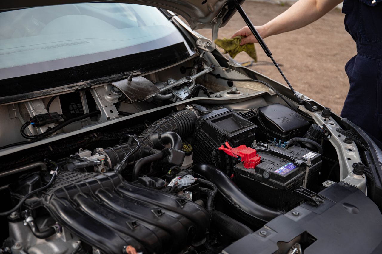 The Art of Drawing Readers In: Your attractive post title goes here Mechanic inspecting car engine bay and battery during routine maintenance.